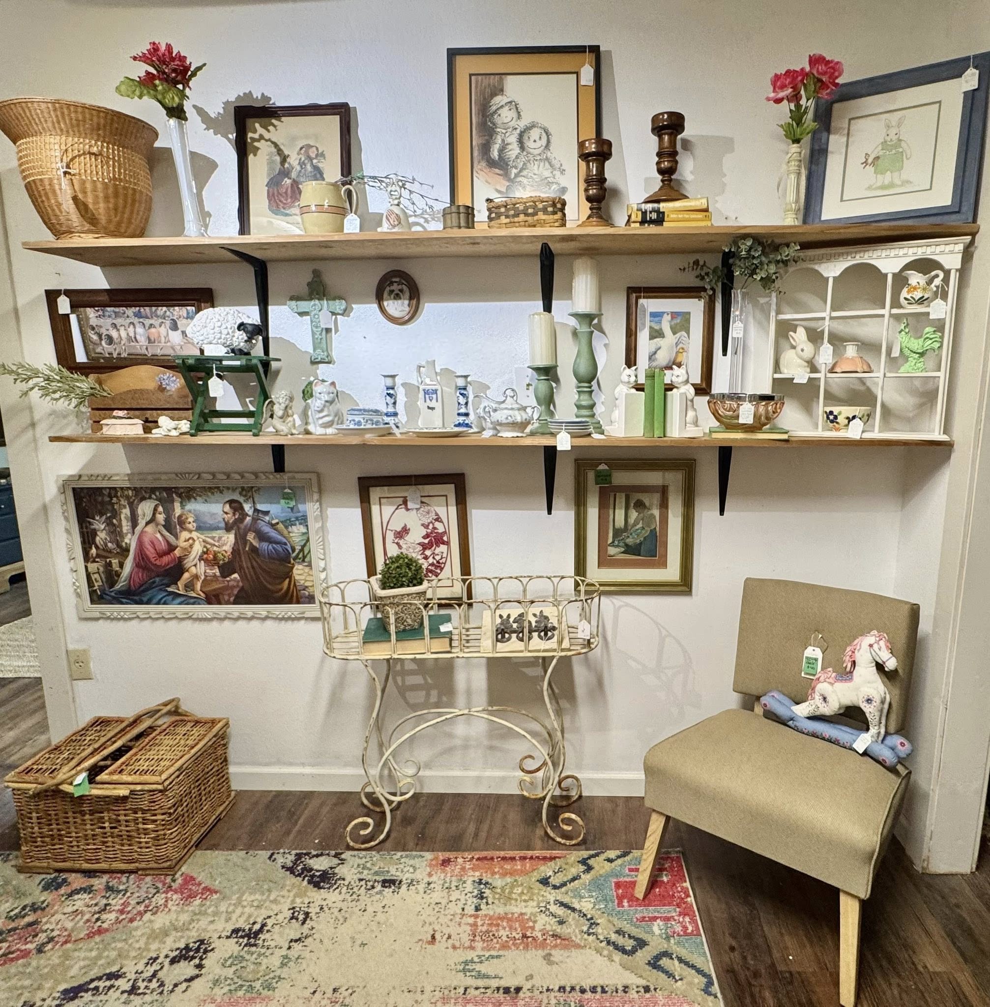 Wall shelf vignette with vintage art, baskets, ceramics, and small decor