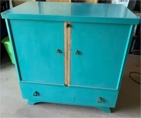 Before: the cabinet in worn turquoise paint with bare wood showing down the middle