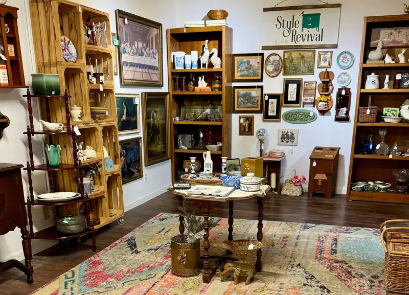 A center table stacked with finds under the Style Revival sign