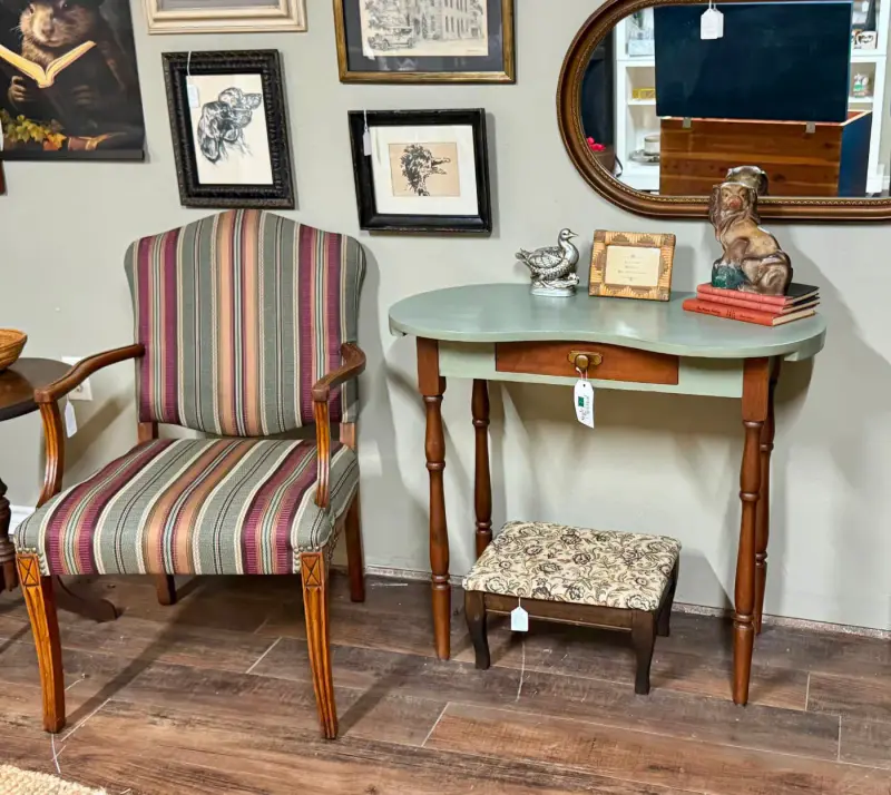 A striped armchair beside a sage vanity