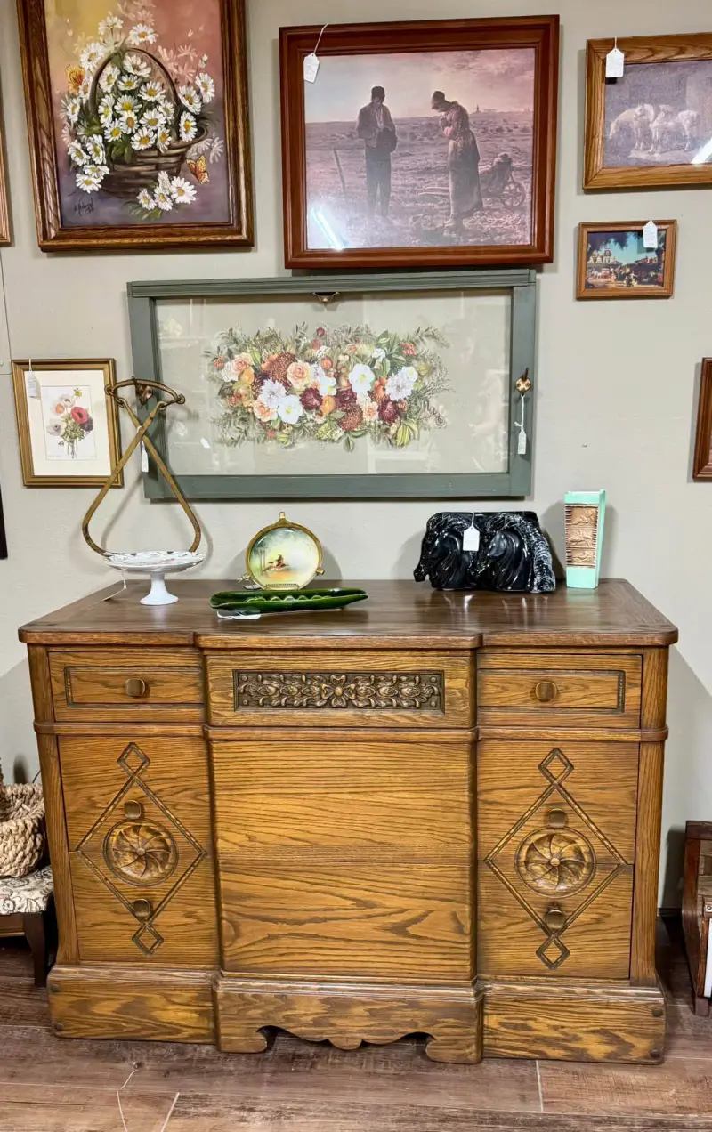 Solid oak buffet with carved diamond details, styled under a framed floral print in Kelli's booth