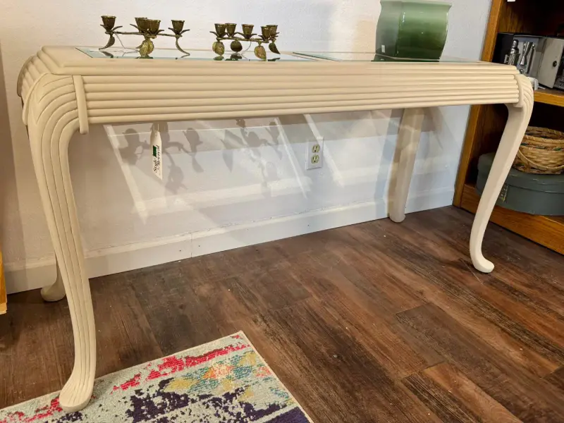 Long cream sofa table with a reeded edge and scrolled legs