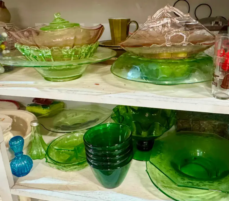 Shelves of green depression glass bowls, plates and candy dishes
