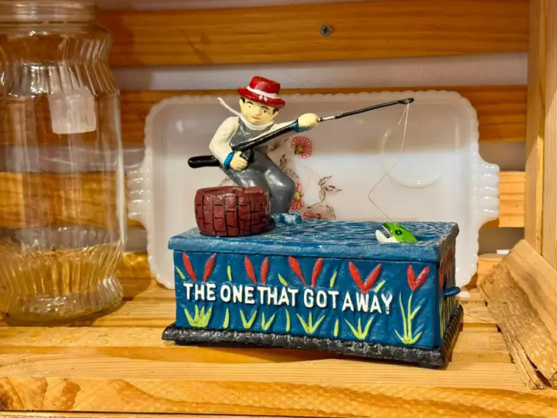 Painted cast mechanical bank of a fisherman, lettered The One That Got Away
