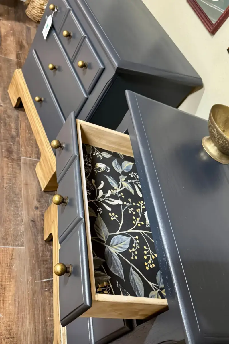 Navy nightstand drawer lined in a black botanical print