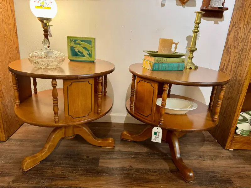 Pair of round two-tier pedestal side tables in warm wood