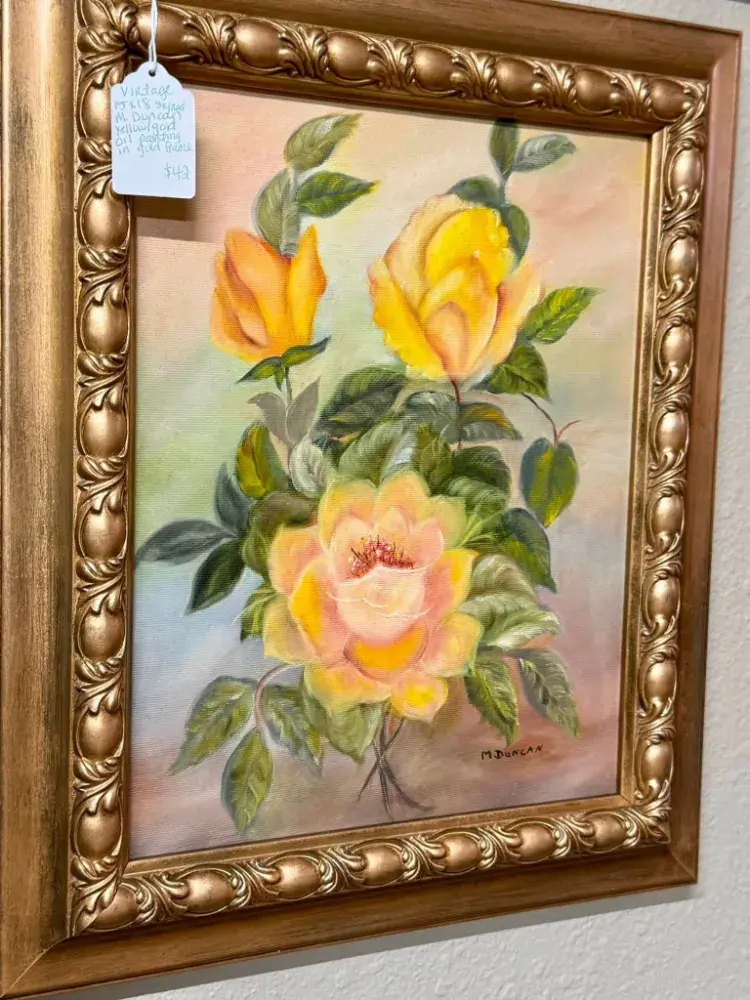 Painting of yellow and peach roses in an ornate gold frame